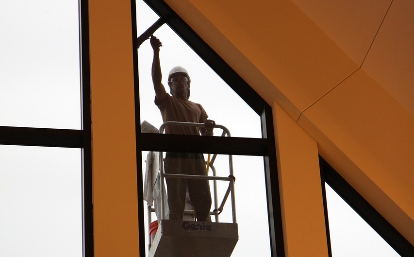 worker using squeegee on window